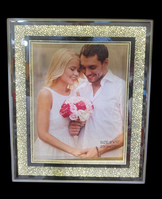 Decorative photo frame with a couple holding flowers inside, on a black background.